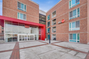 Exterior Courtyard, Entrance to Depot Square, Red brick building, 4 story building, photo taken on a sunny day.